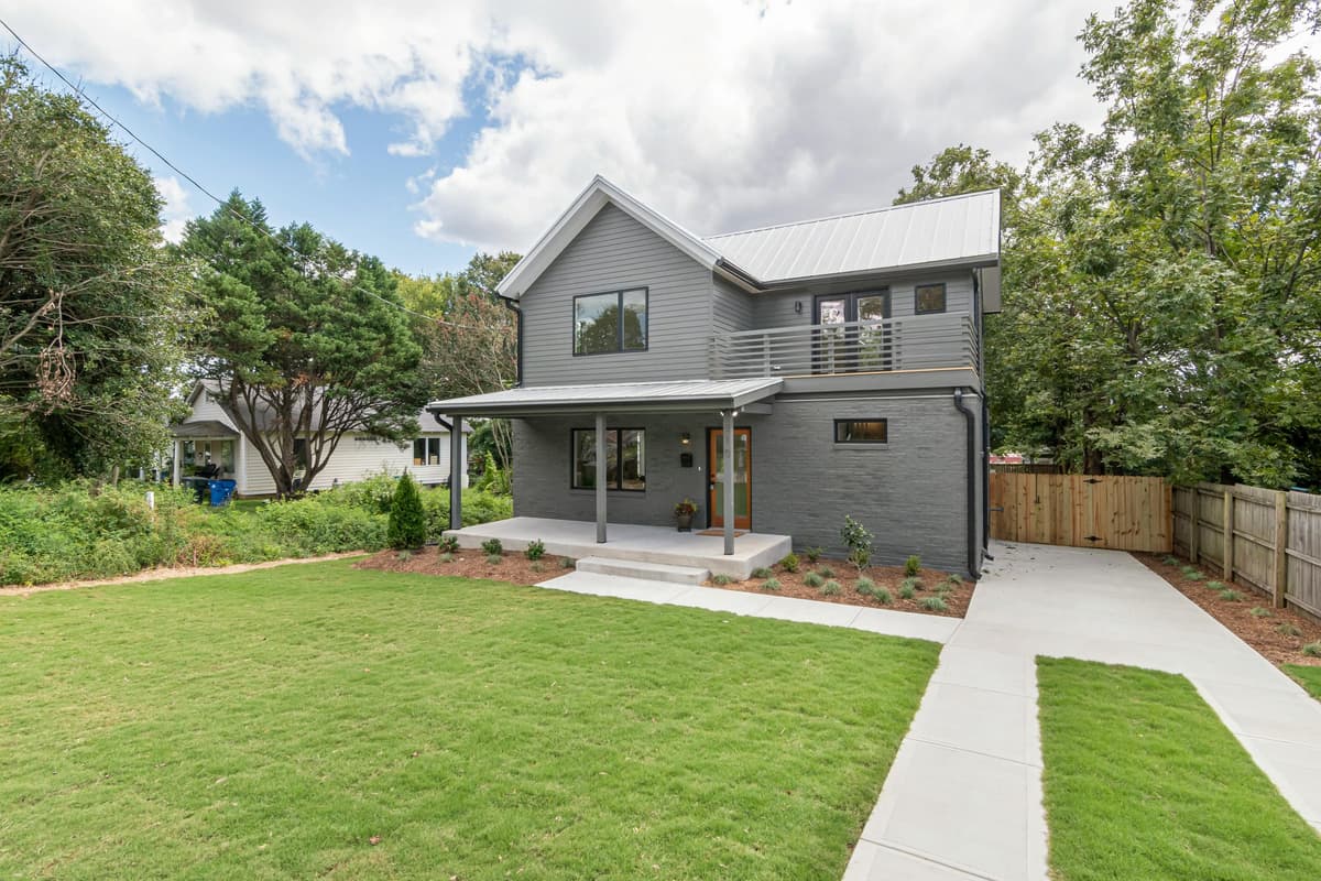 Modern home with a well-maintained front lawn and mulched garden beds